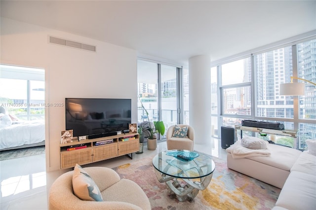 living area with floor to ceiling windows, visible vents, and plenty of natural light