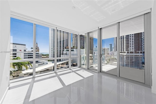 tiled empty room with a wall of windows and a view of city