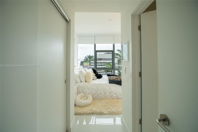 hall with tile patterned flooring and floor to ceiling windows