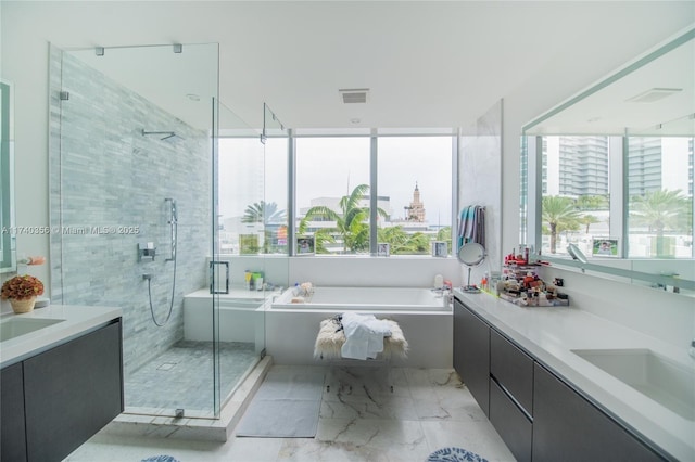 bathroom featuring vanity, marble finish floor, a wealth of natural light, and a stall shower