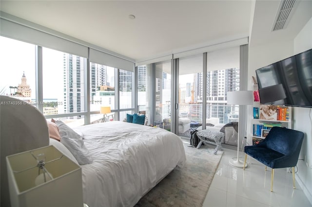 tiled bedroom with visible vents and expansive windows