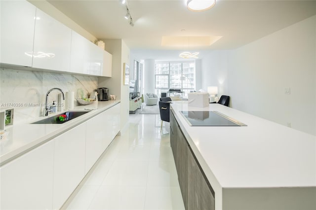 kitchen featuring decorative backsplash, modern cabinets, and a sink