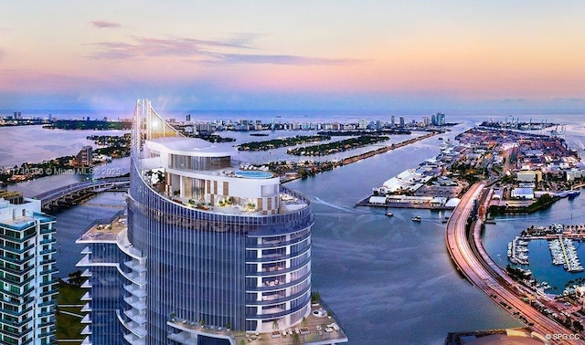 aerial view at dusk featuring a water view