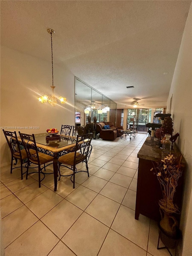 dining space featuring a notable chandelier, light tile patterned floors, and a textured ceiling