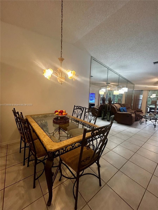 tiled dining space featuring an inviting chandelier and a textured ceiling