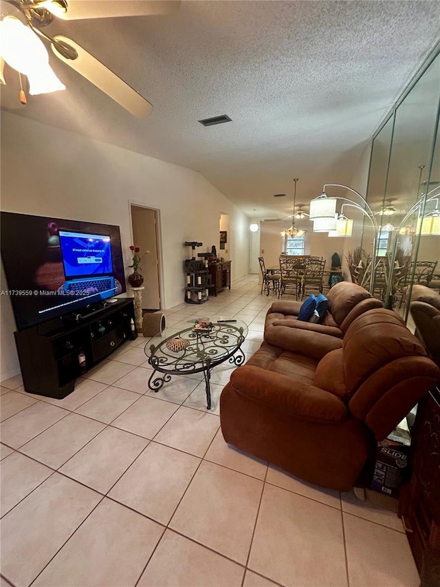 living room with light tile patterned floors, a textured ceiling, and ceiling fan