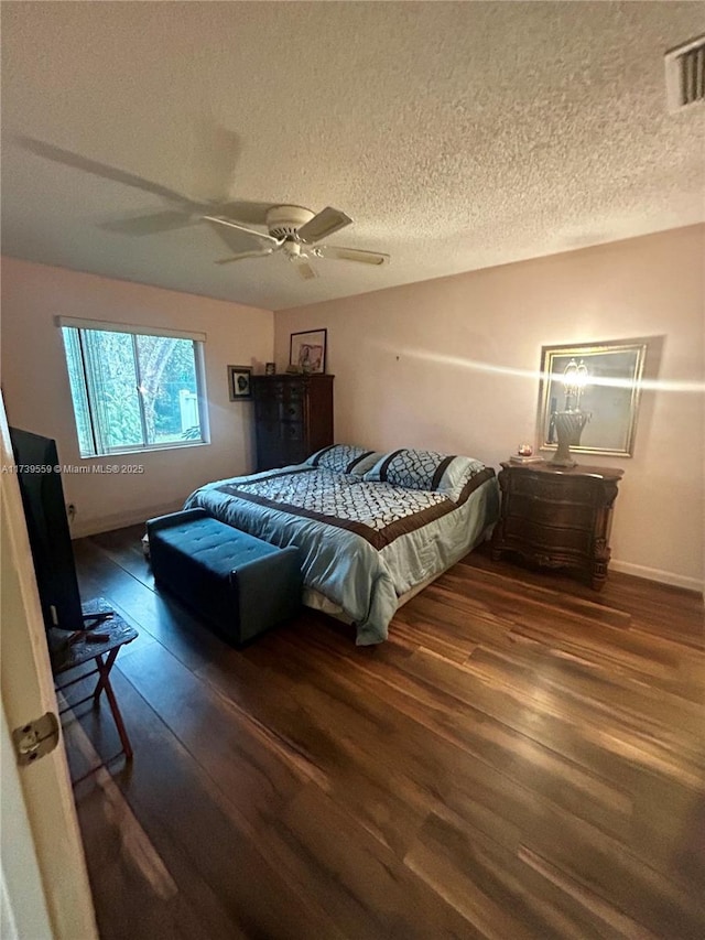 bedroom featuring ceiling fan, a textured ceiling, and dark hardwood / wood-style flooring