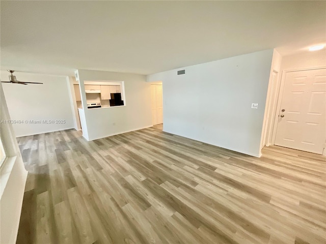 unfurnished living room featuring ceiling fan and light wood-type flooring