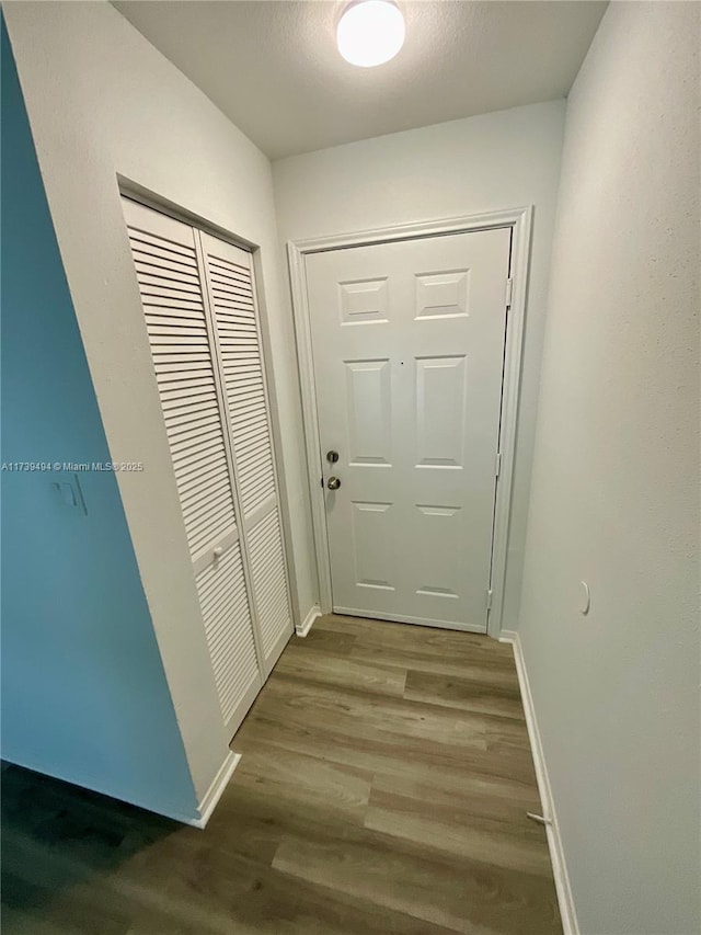 hall with hardwood / wood-style floors and a textured ceiling