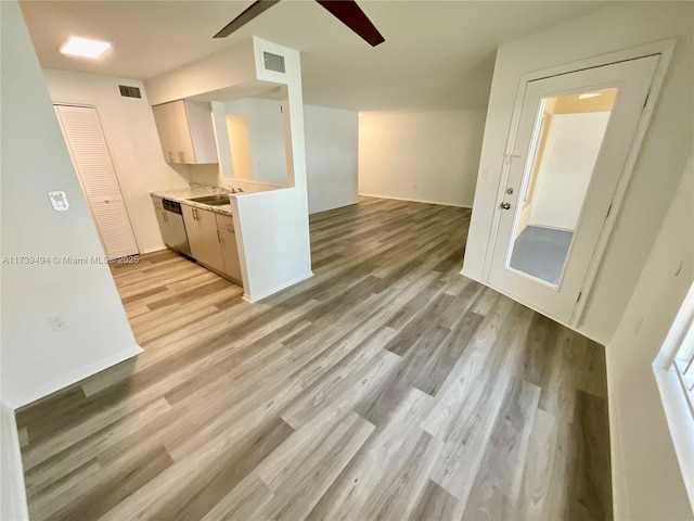 kitchen featuring ceiling fan, sink, stainless steel dishwasher, and light hardwood / wood-style floors