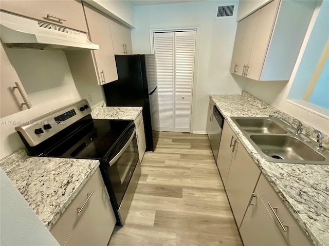 kitchen featuring sink, light hardwood / wood-style flooring, appliances with stainless steel finishes, white cabinetry, and light stone counters