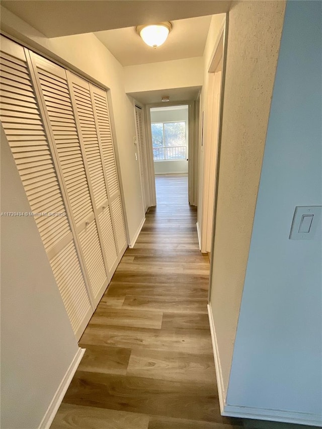 corridor with light hardwood / wood-style flooring