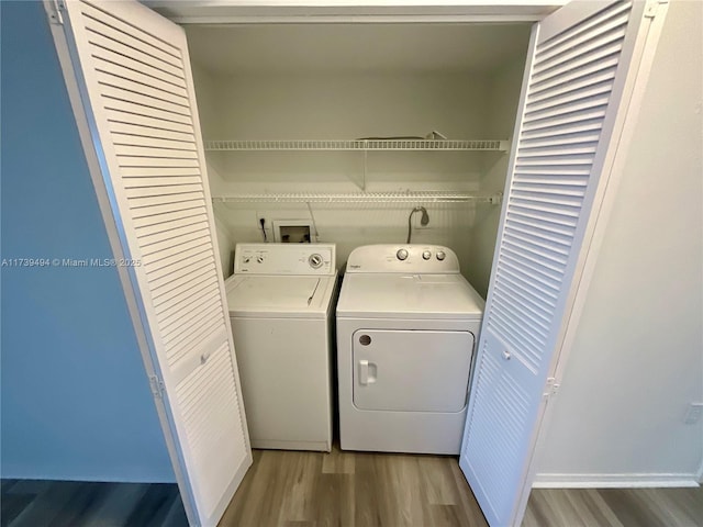 laundry area with washer and clothes dryer and wood-type flooring