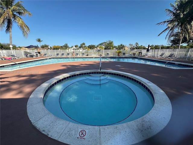 view of swimming pool featuring a hot tub