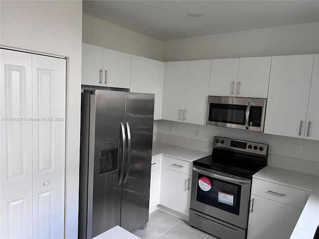 kitchen with light tile patterned floors, white cabinets, and appliances with stainless steel finishes