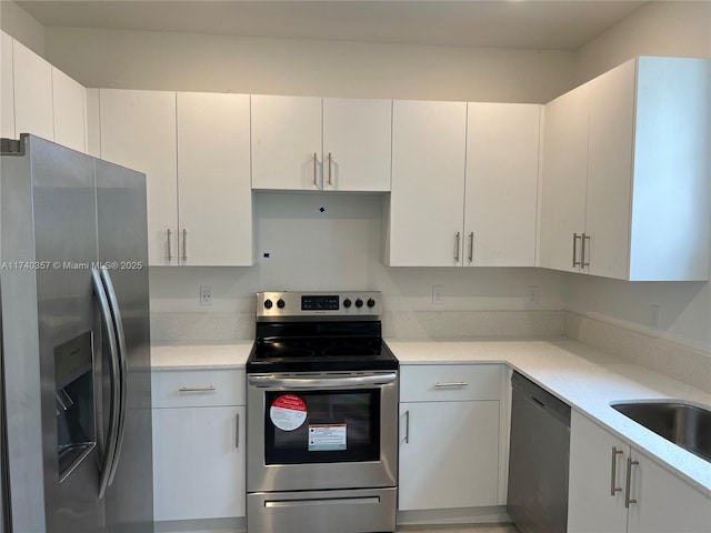 kitchen with white cabinetry, stainless steel appliances, and sink