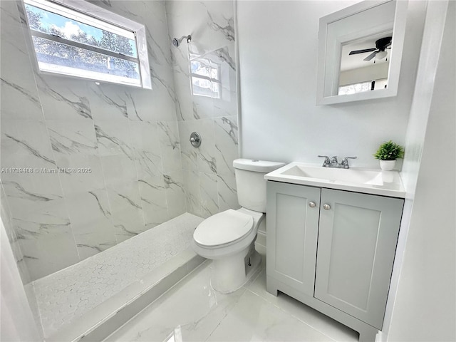 bathroom with vanity, toilet, and a tile shower