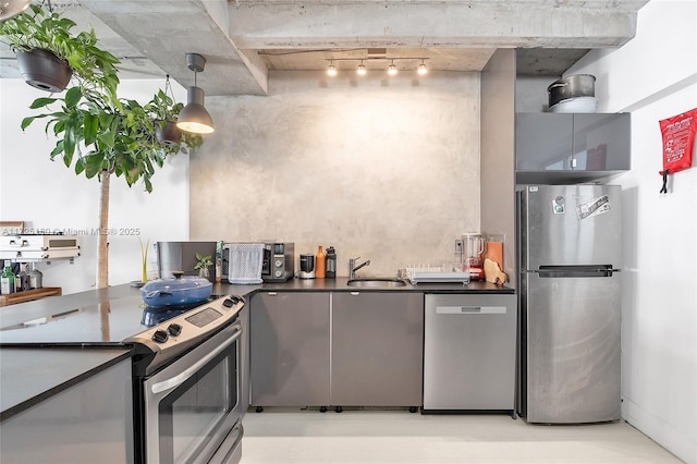 kitchen with sink, rail lighting, and appliances with stainless steel finishes