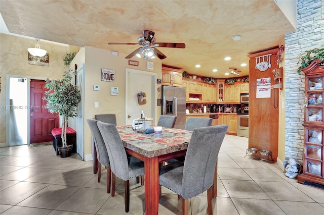 tiled dining area featuring ceiling fan