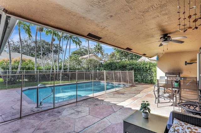 view of pool featuring an outdoor kitchen, a grill, ceiling fan, and a patio area