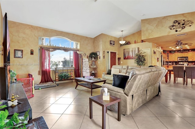 tiled living room with ceiling fan and high vaulted ceiling