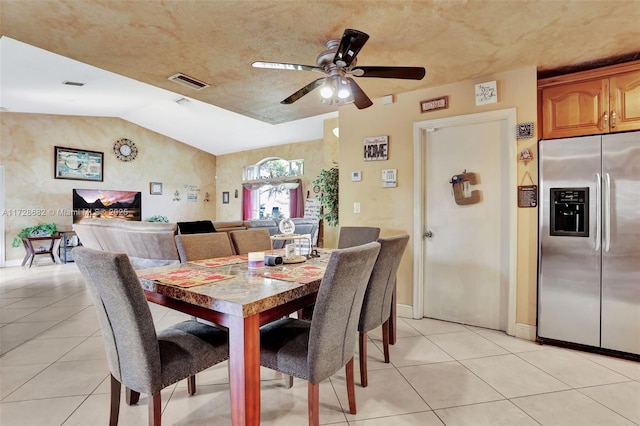 dining area featuring lofted ceiling, light tile patterned floors, and ceiling fan