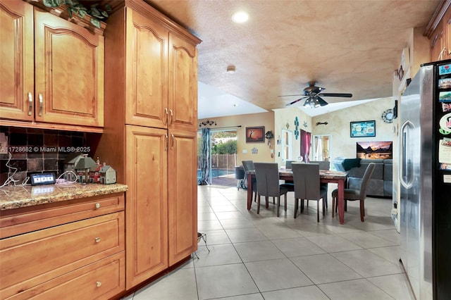 tiled dining room with vaulted ceiling and ceiling fan