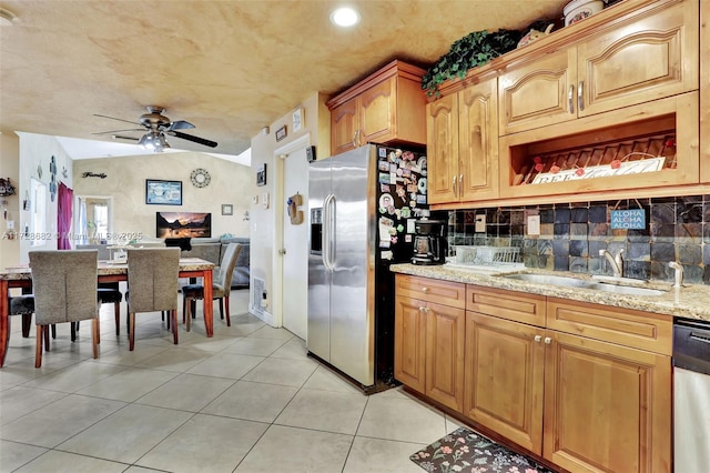 kitchen with appliances with stainless steel finishes, sink, backsplash, light tile patterned floors, and light stone counters