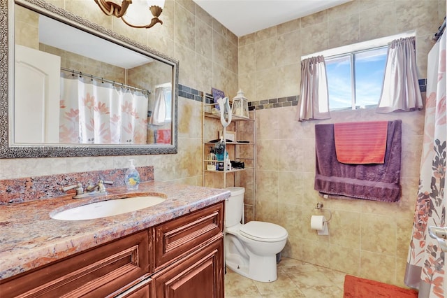 bathroom featuring vanity, toilet, and tile walls