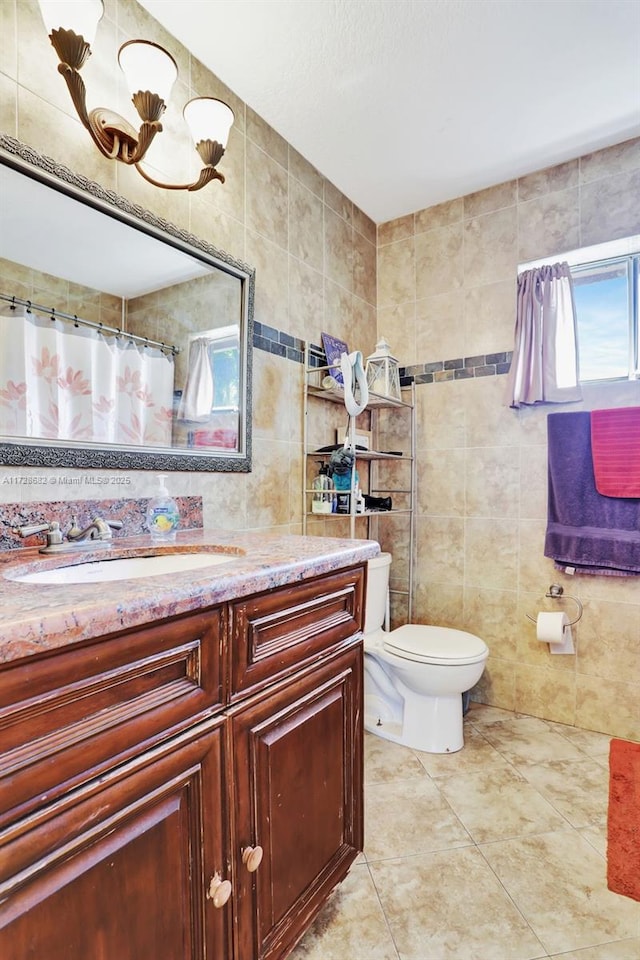 bathroom featuring tile walls, vanity, a wealth of natural light, and toilet