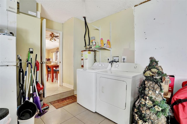 laundry room featuring water heater, light tile patterned floors, ceiling fan, independent washer and dryer, and a textured ceiling