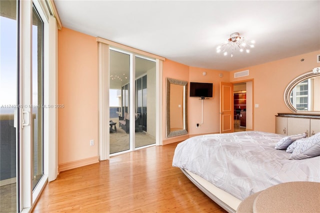 bedroom featuring access to exterior and light hardwood / wood-style flooring