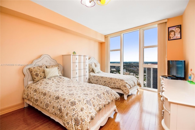 bedroom with hardwood / wood-style floors and a wall of windows