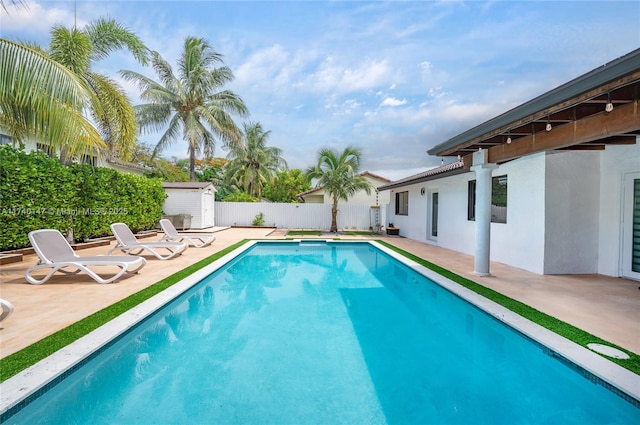 view of pool featuring a patio area and a storage unit