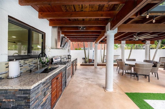 view of patio with sink, ceiling fan, and an outdoor kitchen