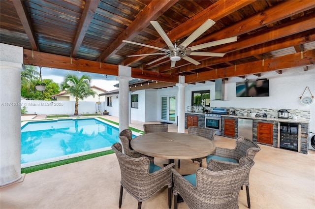 view of swimming pool featuring exterior kitchen, a patio, and ceiling fan