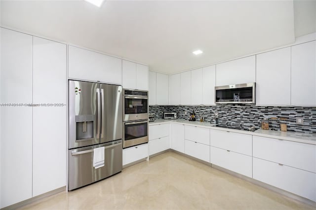 kitchen featuring tasteful backsplash, white cabinets, and appliances with stainless steel finishes