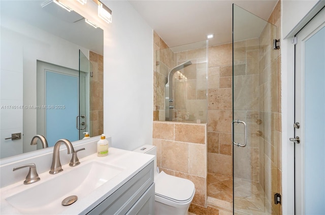 bathroom with vanity, a shower with shower door, and toilet