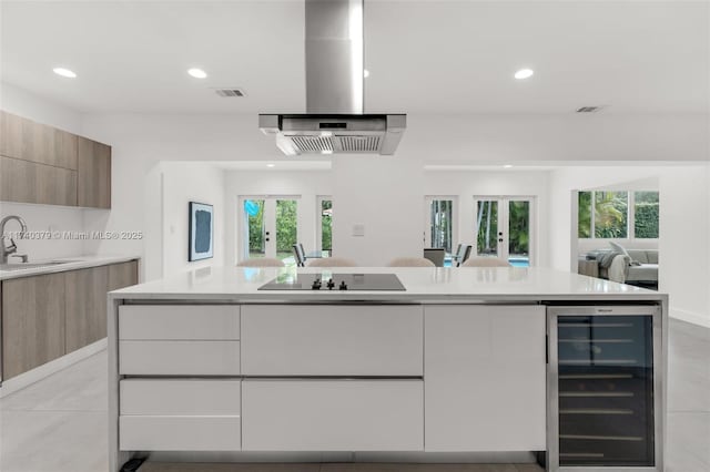 kitchen with wine cooler, black electric cooktop, range hood, and french doors