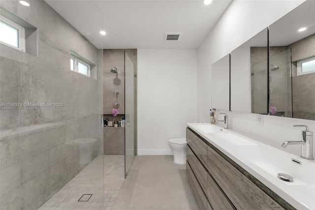 bathroom featuring a wealth of natural light and tiled shower