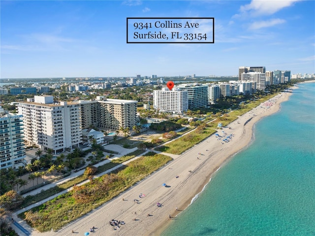 birds eye view of property with a water view and a beach view