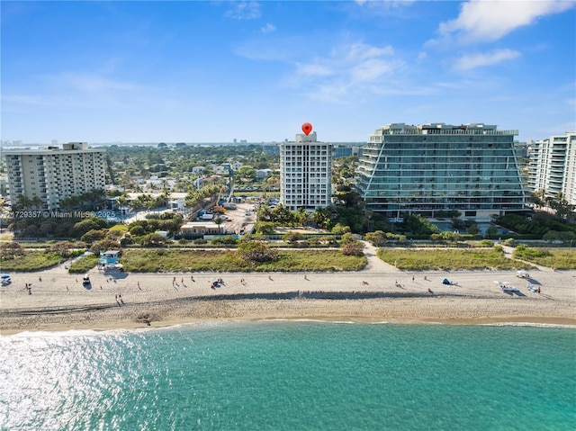 birds eye view of property featuring a water view and a beach view