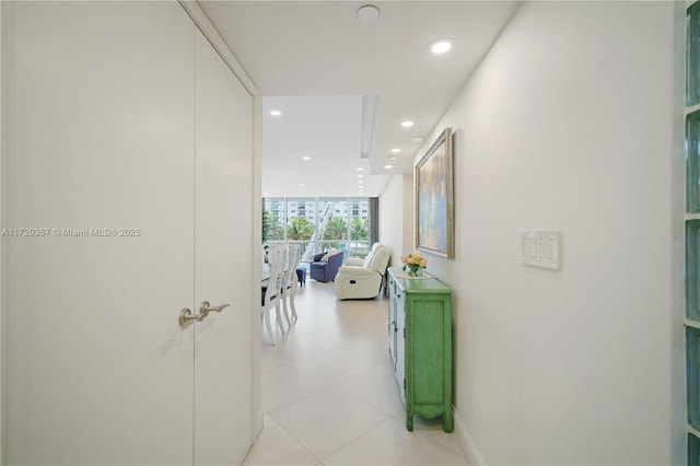 corridor featuring floor to ceiling windows and light tile patterned flooring