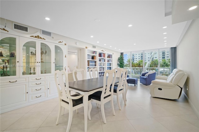 tiled dining area featuring a wall of windows