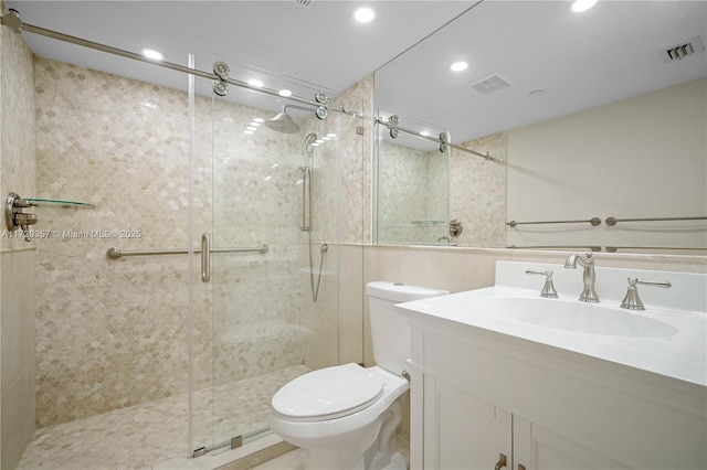 bathroom with vanity, a shower with shower door, and toilet