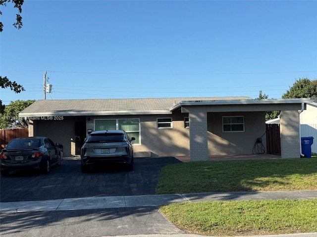 ranch-style house with a carport and a front lawn