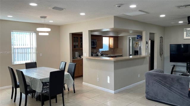 tiled dining room with ceiling fan and a textured ceiling