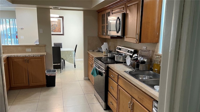 kitchen featuring light tile patterned floors, sink, and appliances with stainless steel finishes