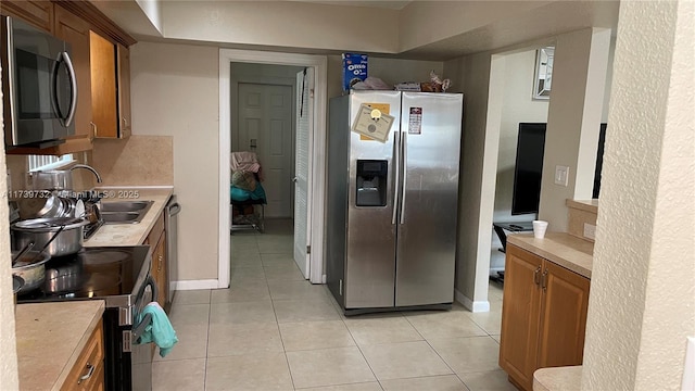 kitchen featuring tasteful backsplash, sink, light tile patterned flooring, and appliances with stainless steel finishes