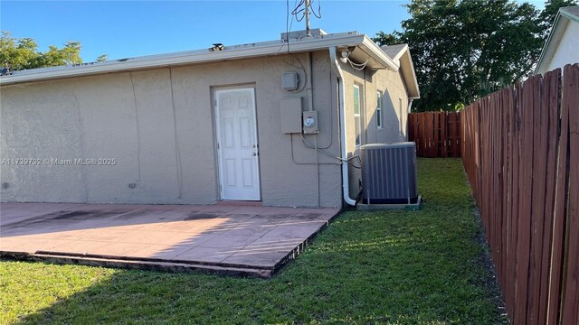 back of house featuring a patio, a yard, and central air condition unit